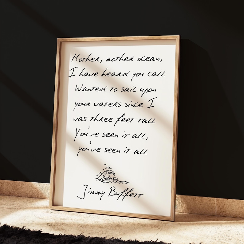 May include: A framed print with a handwritten quote by Jimmy Buffett: "Mother, mother ocean, I have heard you call Wanted to sail upon your waters since I was three feet tall You've seen it all, you've seen it all".