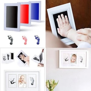 May include: A baby hand and footprint kit with a white frame. The kit includes ink pads in black, red, and blue, and a framed display with a baby's handprint, footprint, and photo. The kit is designed for creating lasting memories.
