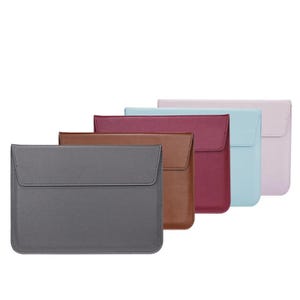 May include: Five laptop sleeves in different colors: gray, brown, burgundy, light blue, and lavender. The sleeves are made of a textured material and have a flap closure.
