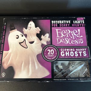 May include: A box of "Eerie Descents" decorative lights for Halloween. The package features a smiling ghost illustration and the text "Glowing Happy Ghosts". The box contains 20 glowing ghost lights for indoor/outdoor use.