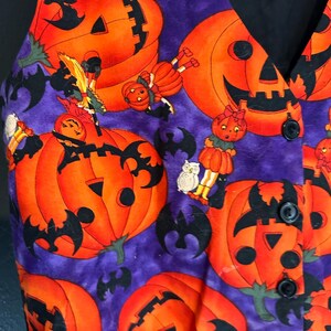 May include: A Halloween-themed vest with a purple background and orange jack-o'-lanterns. Black bats and cartoon figures are scattered across the fabric. The vest has a black collar and buttons.