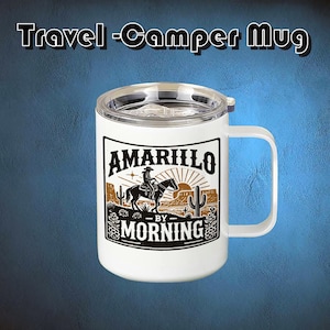 May include: White travel mug with a handle and a clear lid. The mug features a black and brown graphic of a cowboy on a horse with the words "Amarillo by Morning". The text "Travel - Camper Mug" is at the top.