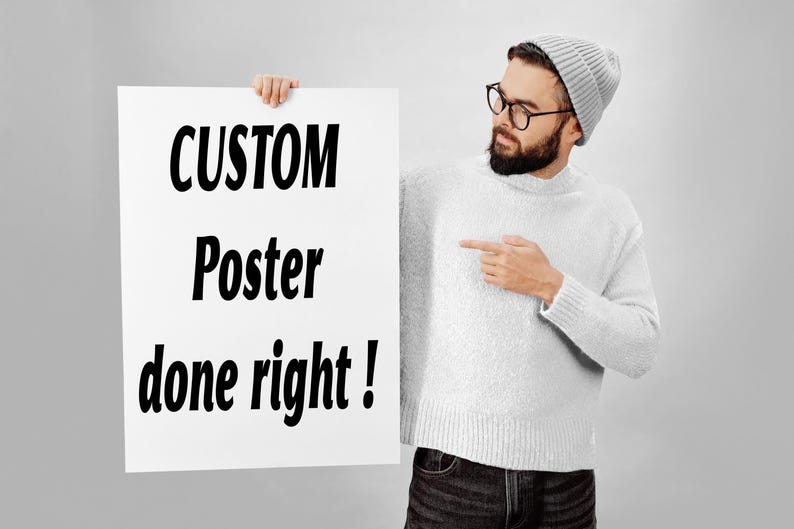 May include: A rectangular white poster featuring the black text CUSTOM Poster done right! in a bold sans-serif font. The poster is held by a person wearing a light grey knit jumper, a matching grey beanie, and dark-rimmed glasses.