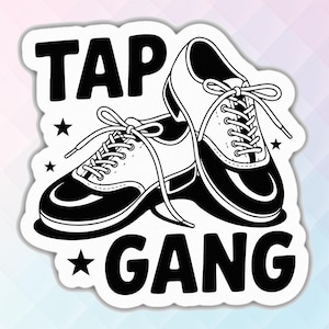 May include: Black and white sticker featuring a pair of tap shoes with laces. The text "TAP GANG" is above and below the shoes, with stars on either side. The sticker has a white border.