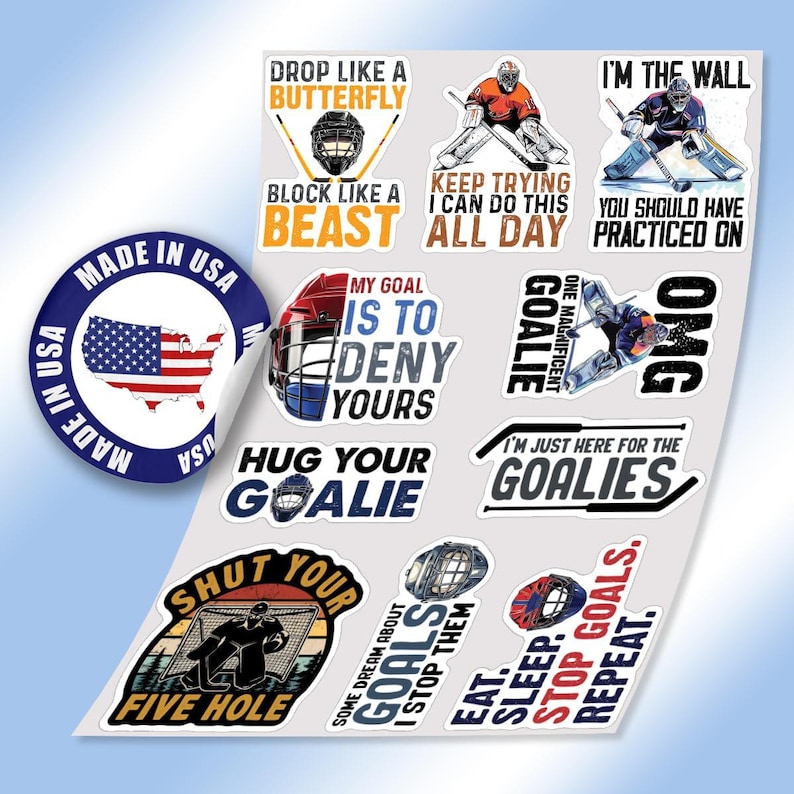 May include: A sheet of hockey-themed stickers with various designs and text. The stickers feature phrases like "Drop Like a Butterfly," "Block Like a Beast," and "I'm the Wall." A "Made in USA" sticker is also included.
