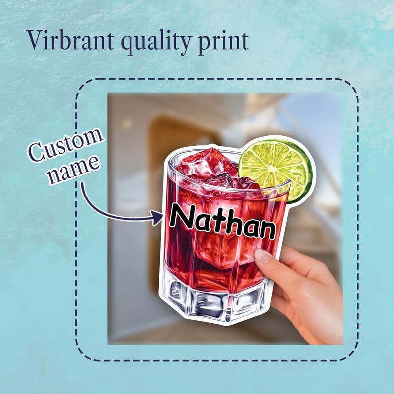 May include: A sticker featuring a glass of red cocktail with ice cubes and a lime slice garnish. The glass has the text Nathan printed on the front. The sticker includes the text Custom name with an arrow pointing to the name and Virbant quality print.