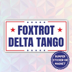 May include: White bumper sticker with red and blue text. The text reads "FOXTROT DELTA TANGO" with a red star on either side of the word "FOXTROT". The sticker has a blue and white circular label that reads "BUMPER STICKER OR MAGNET".