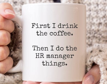 May include: White coffee mug with black text that reads "First I drink the coffee. Then I do the HR manager things."