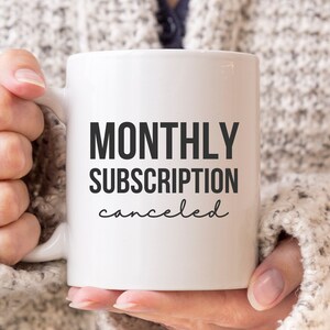 May include: White ceramic coffee mug with black text that reads "MONTHLY SUBSCRIPTION canceled".