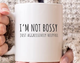 May include: White ceramic mug with black text that reads "I'm not bossy, just aggressively helpful."