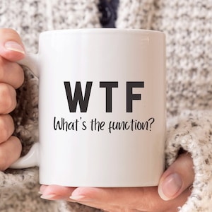 May include: White ceramic coffee mug with black text that reads "WTF What's the function?"