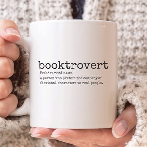 May include: White ceramic mug with the word "booktrovert" and its definition: "[boktrawetl noun A person who prefers the company of fictional characters to real people."