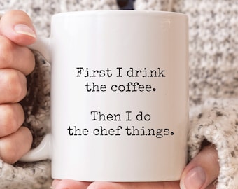 Könnte beinhalten: Eine weiße Keramik-Kaffeetasse mit schwarzem Text, der "First I drink the coffee. Then I do the chef things." lautet.