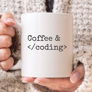 May include: White coffee mug with the text "Coffee & </coding>" in black lettering.