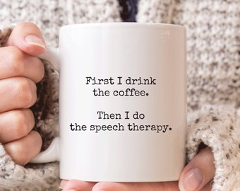 May include: White coffee mug with black text that reads "First I drink the coffee. Then I do the speech therapy."