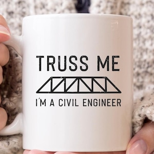 Peut inclure: Une tasse en céramique blanche avec du texte noir qui dit "Truss Me I'm a Civil Engineer" et un graphique noir d'un pont en treillis.