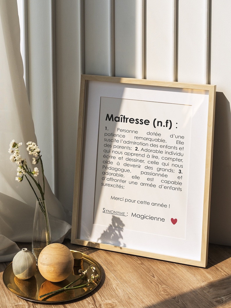 May include: A framed print with a white background and black text. The text reads "Ma&icirc;tresse (n.f): 1. Personne dot&eacute;e d'une patience remarquable. Elle suscite l'admiration des enfants et des parents; 2. Adorable individu qui nous apprend &agrave; lire, compter, &eacute;crire et dessiner, celle qui nous aide &agrave; devenir des grands; 3. P&eacute;dagogue, passionn&eacute;e et adorable, elle est capable d'affronter une arm&eacute;e d'enfants surexcit&eacute;s; Merci pour cette ann&eacute;e! SYNONYME: Magicienne"