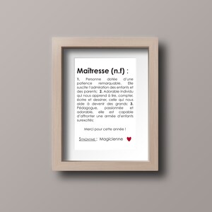 May include: A framed print with a black and white definition of the word "Ma&icirc;tresse" in French. The definition describes a teacher as someone who is patient, inspiring, and capable of handling a classroom of energetic children. The text also includes the phrase "Merci pour cette ann&eacute;e!" and the word "Magicienne" as a synonym.