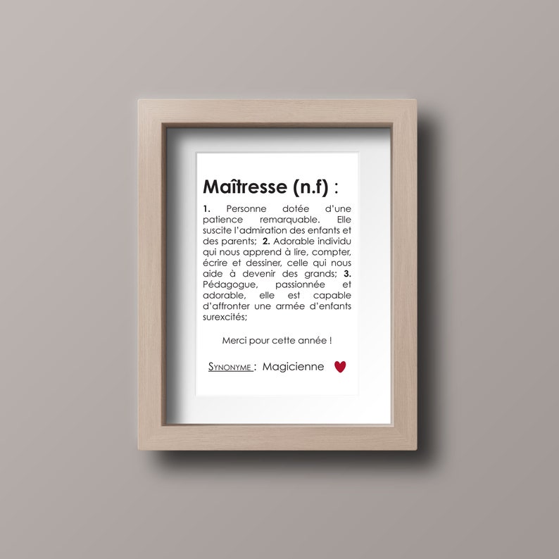 May include: A framed print with a black and white definition of the word "Ma&icirc;tresse" in French. The definition describes a teacher as someone who is patient, inspiring, and capable of handling a classroom of energetic children. The text also includes the phrase "Merci pour cette ann&eacute;e!" and the word "Magicienne" as a synonym.