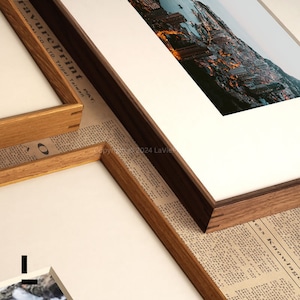 May include: Close-up of a wooden picture frame with a light brown inner frame and a dark brown outer frame. The frame is on top of a piece of paper with text. The text on the paper reads "ravurePrint PAT. A CO.,LTD. Taipei Taiwan" and "Copyright 2024 LaVie".