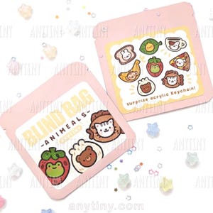 Op de afbeelding: Twee roze blind bags met cartoon dierenontwerpen. Eén zakje heeft het opschrift "BLIND BAG - ANIMALS". De andere zak heeft een label met de tekst "surprise acrylic Keychain!" met dierlijke personages met een voedselthema. Stervormige confetti is verspreid.