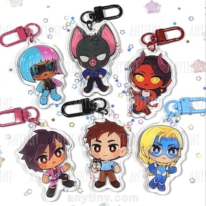 Può includere: Collezione di portachiavi in acrilico con personaggi dei cartoni animati con vari design. I portachiavi hanno dettagli colorati e chiusure in metallo. I personaggi includono un pipistrello, un diavolo e un supereroe.