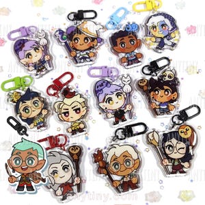 May include: A collection of colorful acrylic keychains featuring cartoon characters with various accessories. Each keychain has a metal clasp for easy attachment. The characters have distinct outfits and expressions, with some holding staffs or small animals.