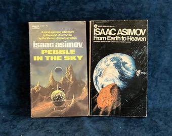 Może przedstawiać: Dwie książki science fiction w miękkiej oprawie autorstwa Isaaca Asimova. Książka po lewej nosi tytuł "Pebble in the Sky" i przedstawia futurystyczny krajobraz z statkiem kosmicznym. Książka po prawej nosi tytuł "From Earth to Heaven" i przedstawia zbliżenie Ziemi z kometą na pierwszym planie.