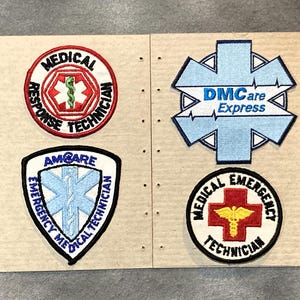 May include: Four embroidered patches with medical and emergency service themes. The patches feature text like "Medical Response Technician," "DMCare Express," and "Emergency Medical Technician." Colors include red, white, blue, and black.