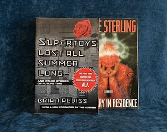 May include: Two paperback books, one titled "Supertoys Last All Summer Long" by Brian Aldiss with a new foreword by the author, and the other titled "Story in Residence" by Bruce Sterling. The Aldiss book has a red rose on the cover and a sticker that says "The story that inspired the Steven Spielberg film A.I."