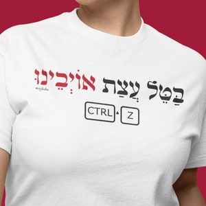 May include: White t-shirt with red Hebrew text that reads "בפעם עשרת אלף" and the text "CTRL + Z" in black below it.