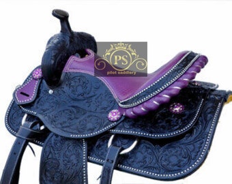 May include: A black leather saddle with purple accents and intricate floral tooling. The saddle features a 'PS pilot saddlery' logo.