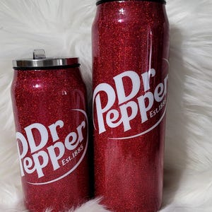 Puede incluir: Dos vasos aislados rojos con purpurina con un logotipo blanco de Dr Pepper y el texto "Est. 1885".