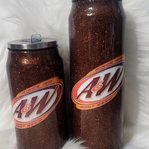 Puede incluir: Dos vasos aislados de purpurina marr&oacute;n con un logotipo blanco de A&W Root Beer. El vaso m&aacute;s grande es de 20 oz y el m&aacute;s peque&ntilde;o de 12 oz. Ambos vasos tienen una tapa de acero inoxidable.