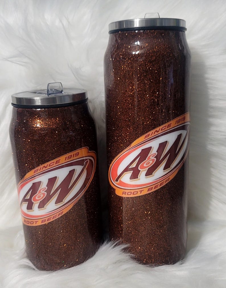 Puede incluir: Dos vasos aislados de purpurina marr&oacute;n con un logotipo blanco de A&W Root Beer. El vaso m&aacute;s grande es de 20 oz y el m&aacute;s peque&ntilde;o de 12 oz. Ambos vasos tienen una tapa de acero inoxidable.