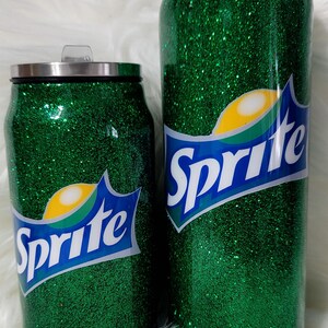 Puede incluir: Dos vasos aislados de purpurina verde con un logotipo de Sprite. Los vasos tienen la forma de una lata.