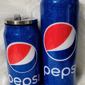 Puede incluir: Dos vasos aislados de purpurina azul con un logotipo de Pepsi y la palabra "Pepsi" en ellos.