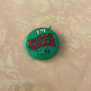 May include: A green button with the text "I'M FULLA BULLA" in red letters and a black bull illustration.