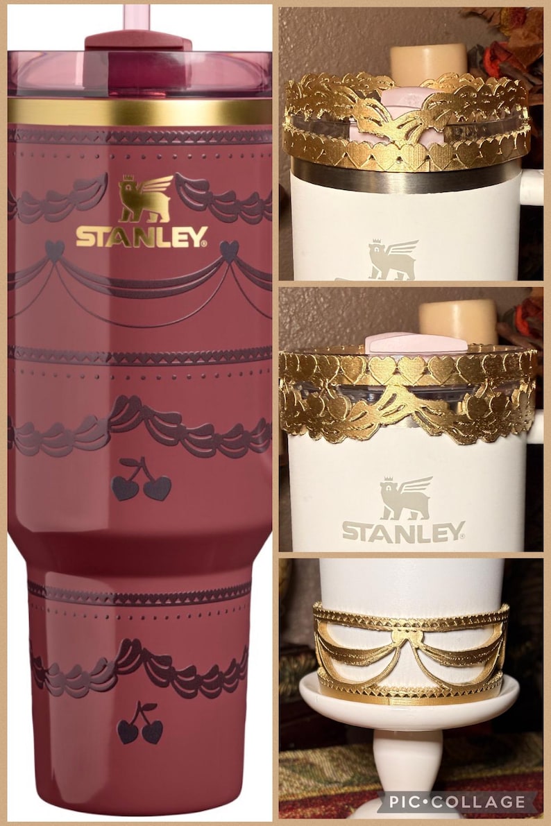 May include: A maroon Stanley tumbler with a decorative design, featuring cherries and a gold logo. The image also shows white Stanley tumblers with gold decorative bands, including heart and bow designs.