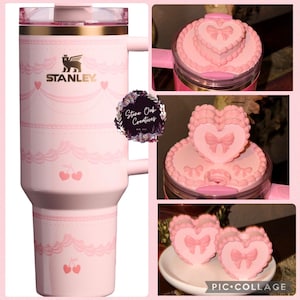 May include: A pink Stanley travel mug with a gold rim and handle, adorned with a cherry and lace design. The mug displays the Stanley logo and a heart-shaped lid. Additional images show heart-shaped toppers.