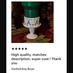 May include: A white, pedestal-style cake stand with a decorative, circular trim. The stand supports a green object. The text on the image says "High quality, matches description, super cute ! Thank you".