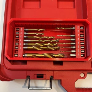 May include: A red plastic case with a black handle, containing a set of drill bits. The drill bits are labeled with their sizes in inches, including 1/16", 5/64", 3/32", 7/64", 1/8", 9/64", 5/32", 3/16", 7/32", 1/4", 5/16", 3/8", and 1/2".