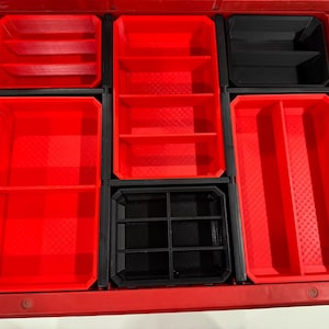 Peut inclure: Un organisateur de tiroir en plastique rouge avec plusieurs compartiments. L'organisateur comporte des plateaux rouges et noirs de différentes tailles et configurations, conçus pour le stockage ou l'organisation d'outils. Le tiroir est ouvert, révélant l'intérieur.