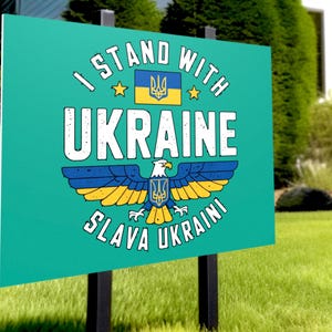 A yard sign mockup displayed on a green lawn in front of a suburban house.  It features the Ukraine Eagle design.