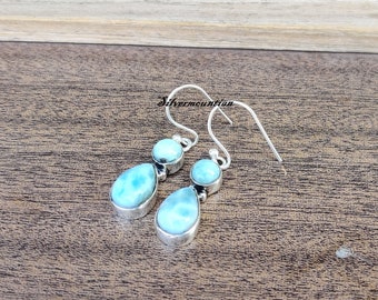 Könnte beinhalten: Ein Paar silberne Ohrhänger mit tropfenförmigen blauen und weißen Edelsteinen. Die Ohrringe haben ein schlichtes Design und sind perfekt für den Alltag.