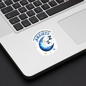 May include: A white sticker with a blue crescent moon and stars. The text on the sticker reads "Who needs sleep when you have anxiety ZZZ".