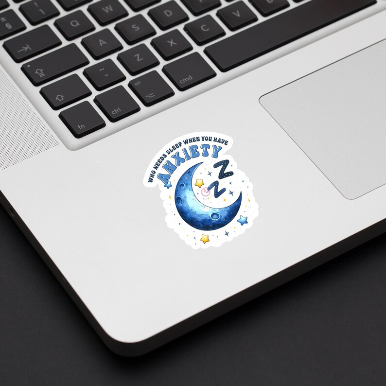 May include: A white sticker with a blue crescent moon and stars. The text on the sticker reads "Who needs sleep when you have anxiety ZZZ".