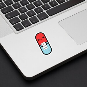 Picture shows the sticker described in the last image placed on a laptop to show size. The sticker sits to the left of the laptop track pad, a little smaller in height to the pad. It is about 2 keys in width.