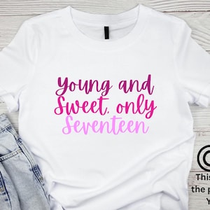 Könnte beinhalten: Weißes T-Shirt mit dem Text "Young and Sweet, only Seventeen" in einem Farbverlauf von Pink und Lila. Das Shirt wird mit blauen Jeans kombiniert. Das Design ist Eigentum von YOURuk.