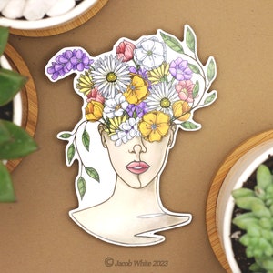 May include: A sticker featuring a line drawing of a person with a variety of colorful flowers growing out of their head. The flowers are yellow, orange, pink, purple, and white. The sticker is on a brown background.